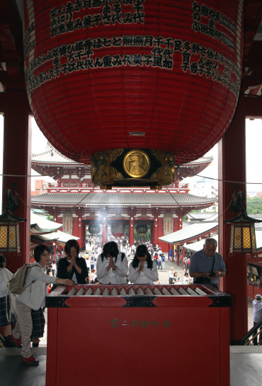 orando Templo Sensoji, Asakusa, Tokio